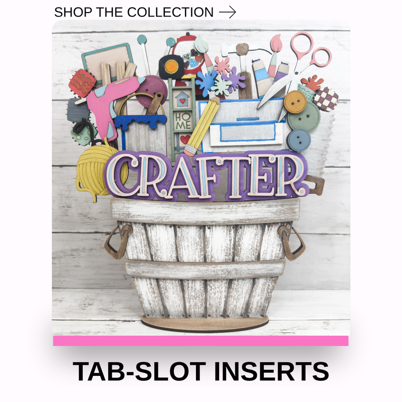 A decorative craft-themed sign shaped like a rustic white bucket filled with colorful craft supplies and a large purple 'CRAFTER' sign. The image includes the text 'SHOP THE COLLECTION →' at the top and 'TAB-SLOT INSERTS' at the bottom, indicating this is a product listing graphic for craft tab inserts.